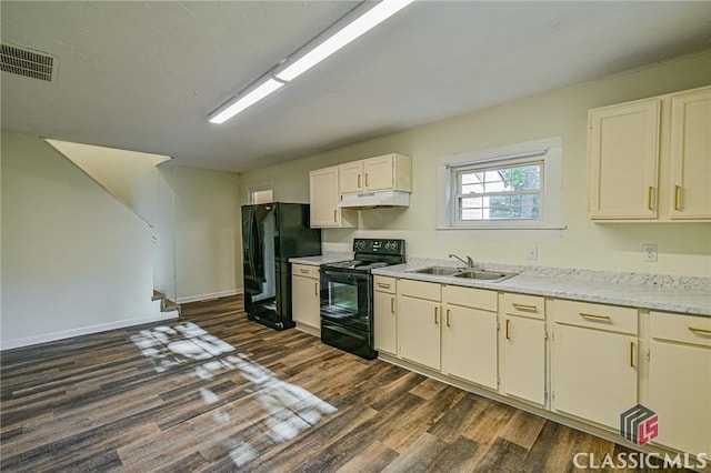 kitchen featuring dark wood-type flooring, sink, and black appliances