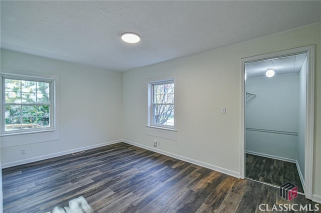 spare room with dark hardwood / wood-style floors and a healthy amount of sunlight