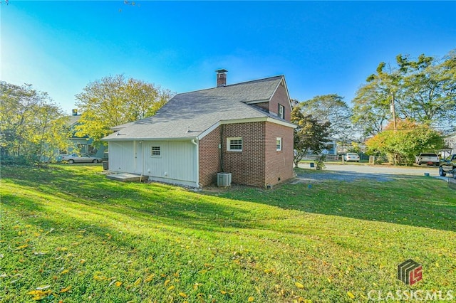 view of side of property featuring a yard and cooling unit