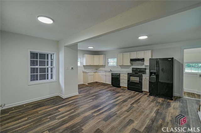 kitchen featuring white cabinetry, dark wood-type flooring, black appliances, and sink