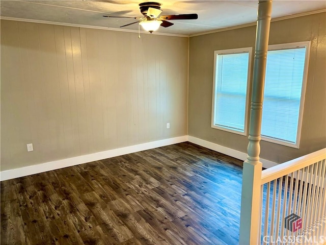 unfurnished room featuring wooden walls, dark hardwood / wood-style floors, ceiling fan, and crown molding