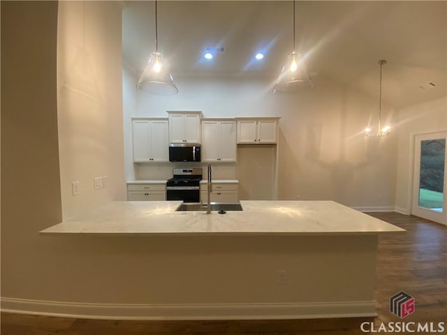 kitchen with hanging light fixtures, white cabinets, stainless steel appliances, and dark hardwood / wood-style floors