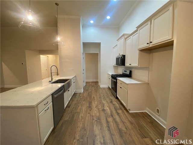 kitchen with white cabinets, crown molding, dark hardwood / wood-style floors, decorative light fixtures, and stainless steel appliances