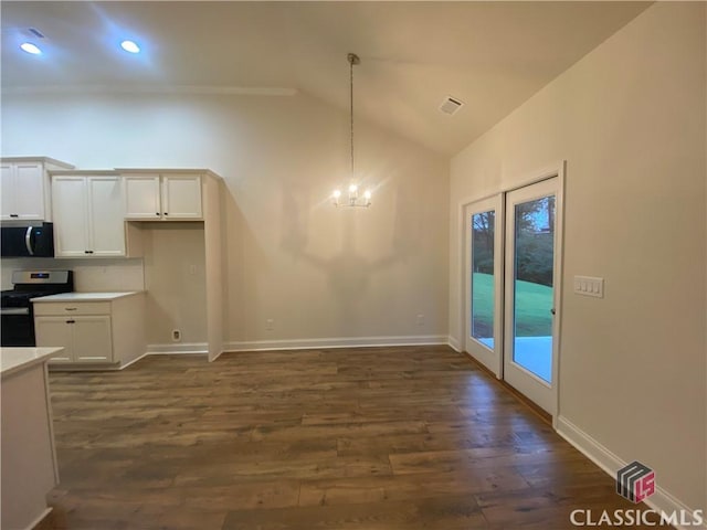 kitchen featuring dark wood-type flooring, vaulted ceiling, decorative light fixtures, white cabinetry, and stainless steel appliances