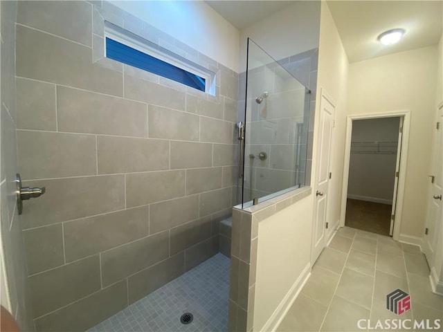 bathroom with a tile shower and tile patterned floors