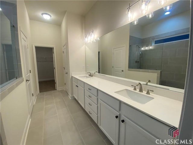 bathroom with tile patterned floors, vanity, and a tile shower