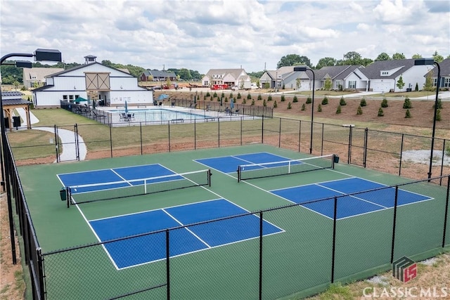 view of tennis court featuring basketball hoop