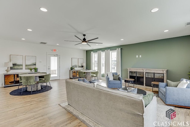 living room featuring light wood-type flooring and ceiling fan