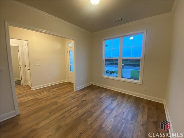 empty room featuring dark hardwood / wood-style floors and ornamental molding