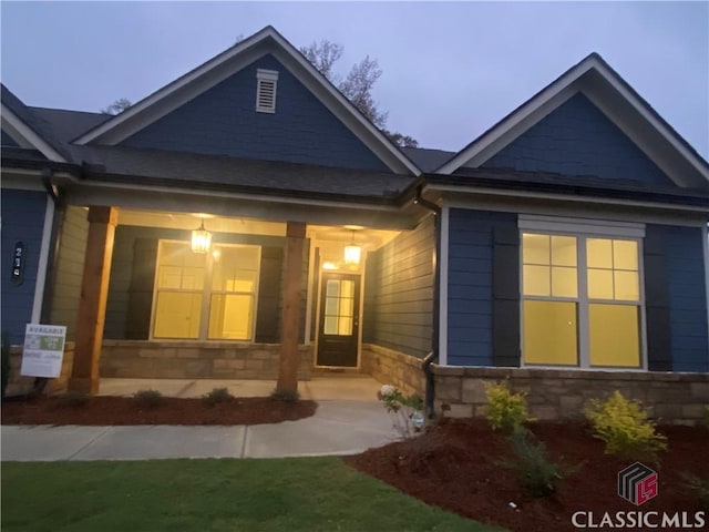 back house at dusk with covered porch