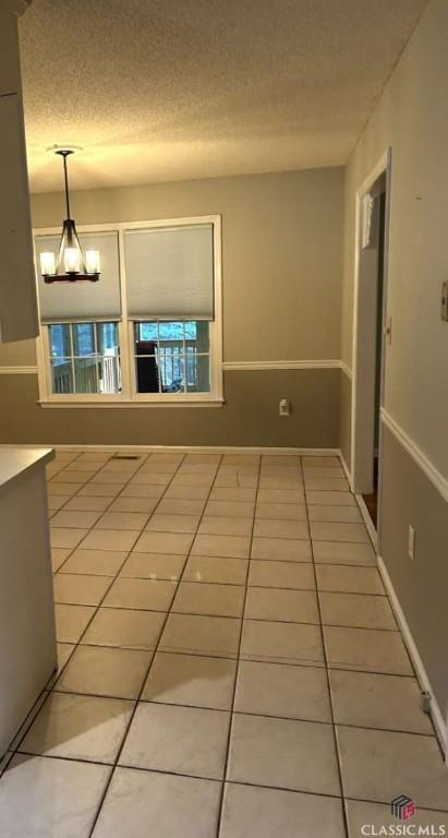 corridor with tile patterned floors and a textured ceiling