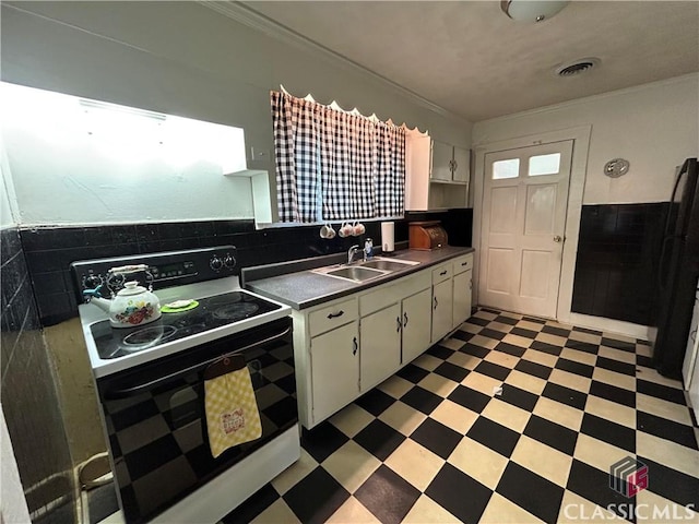 kitchen featuring electric range, white cabinetry, and sink