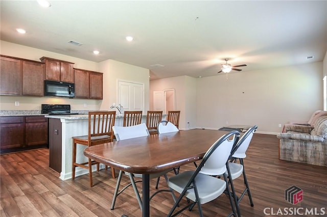 dining space with ceiling fan and dark hardwood / wood-style floors