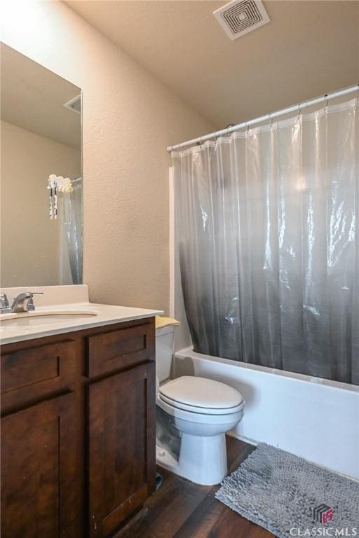 full bathroom featuring hardwood / wood-style flooring, vanity, toilet, and shower / bath combo with shower curtain