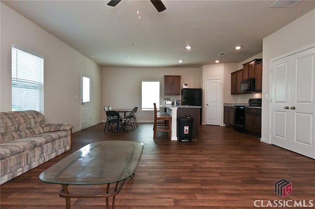 living room with ceiling fan and dark hardwood / wood-style flooring