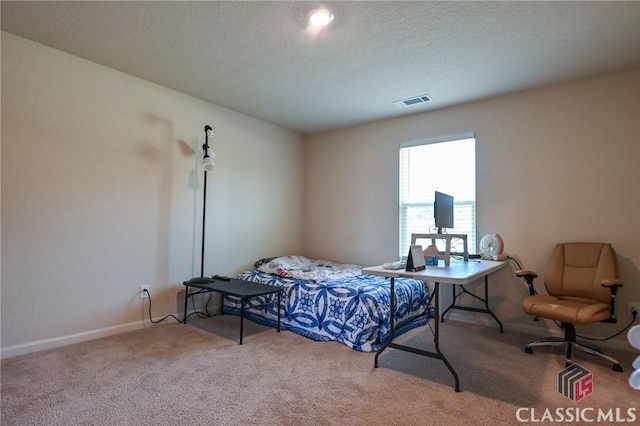 bedroom featuring carpet floors and a textured ceiling