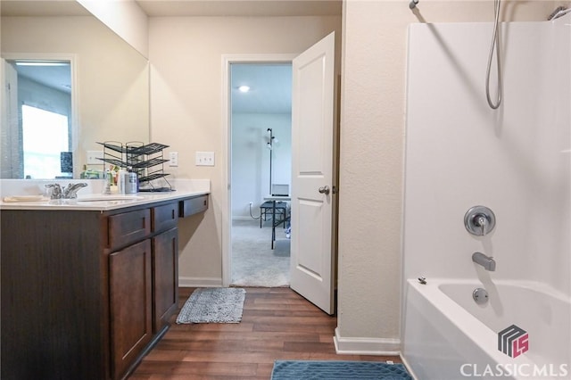 bathroom with hardwood / wood-style floors, vanity, and  shower combination