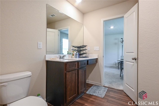 bathroom with vanity, wood-type flooring, and toilet