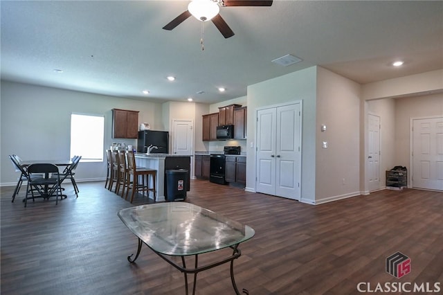 living room with ceiling fan and dark wood-type flooring