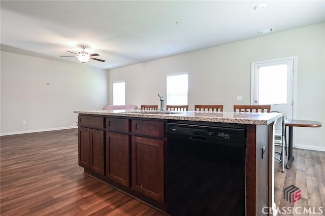 kitchen featuring a kitchen breakfast bar, dishwasher, a kitchen island, and dark wood-type flooring