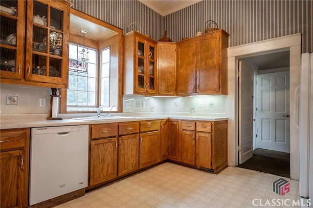 kitchen with decorative backsplash, white appliances, and sink