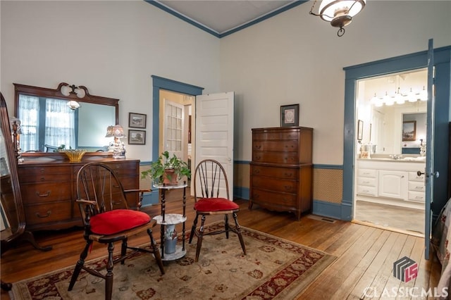 living area featuring hardwood / wood-style floors, sink, and crown molding