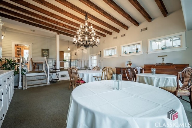 dining space with dark colored carpet, beam ceiling, plenty of natural light, and a notable chandelier