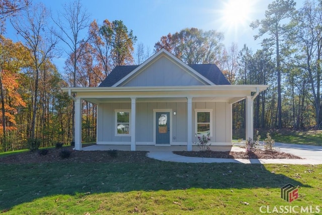 view of front of home featuring covered porch and a front lawn