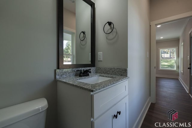 bathroom featuring crown molding, vanity, toilet, and hardwood / wood-style floors