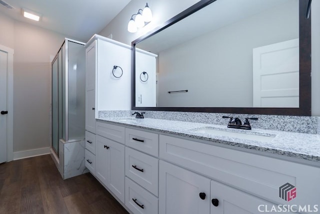 bathroom featuring vanity, a shower with shower door, and hardwood / wood-style floors