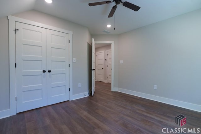 unfurnished bedroom with ceiling fan, dark hardwood / wood-style floors, vaulted ceiling, and a closet