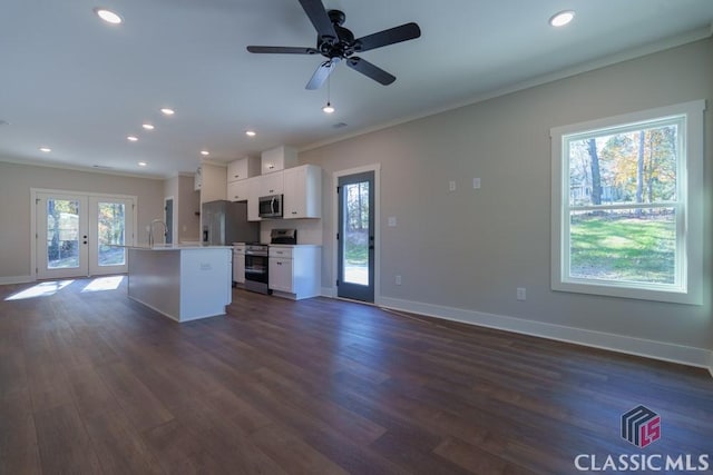 kitchen featuring crown molding, appliances with stainless steel finishes, dark hardwood / wood-style floors, a kitchen island with sink, and white cabinets