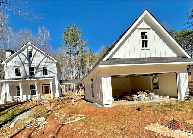 exterior space featuring a chimney, a shingled roof, covered porch, board and batten siding, and a garage