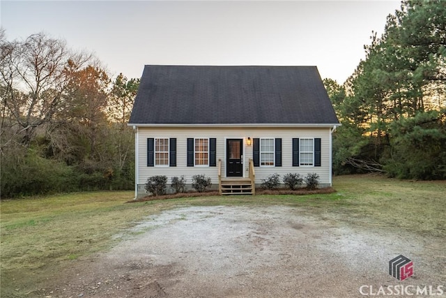 cape cod home with a yard