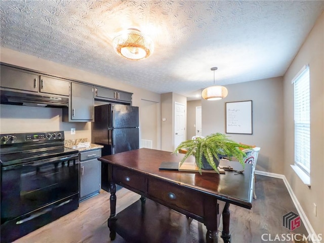 kitchen with black appliances, hanging light fixtures, gray cabinets, and light hardwood / wood-style flooring