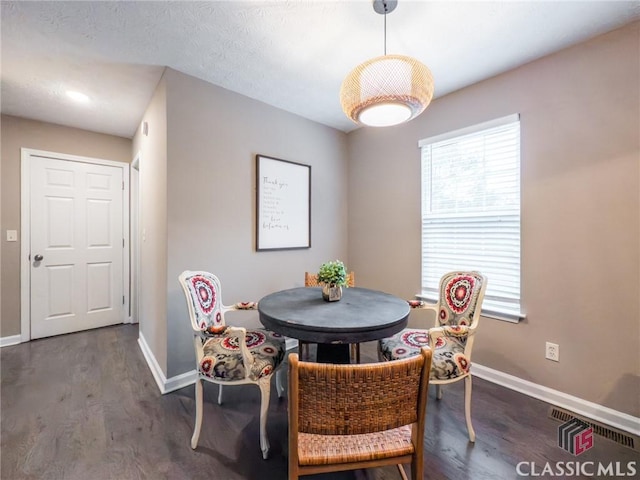 dining space featuring a healthy amount of sunlight and dark hardwood / wood-style floors