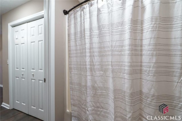 bathroom featuring shower / bath combo with shower curtain and hardwood / wood-style flooring