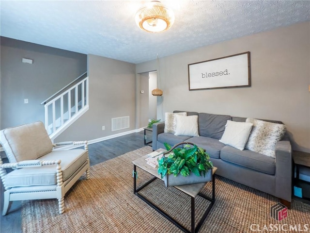 living room with a textured ceiling and wood-type flooring