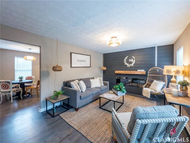 living room featuring a healthy amount of sunlight, dark hardwood / wood-style floors, and a textured ceiling