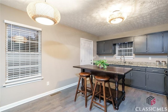 kitchen with dark hardwood / wood-style floors, sink, gray cabinets, and a textured ceiling