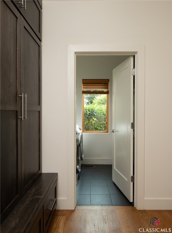 washroom featuring dark wood-type flooring and independent washer and dryer