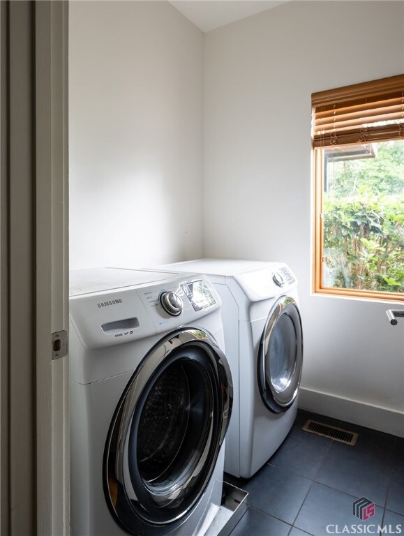 laundry area featuring washer and clothes dryer and tile patterned flooring