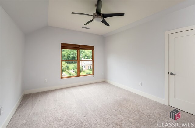 empty room with ceiling fan, light carpet, and vaulted ceiling