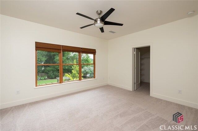 carpeted spare room featuring ceiling fan