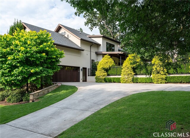 view of front of property featuring a front yard and a garage