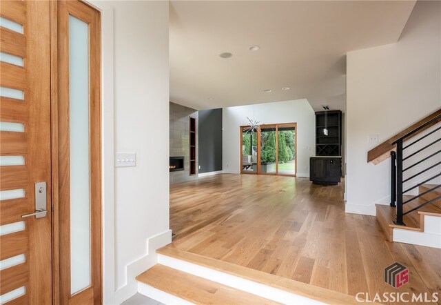 foyer featuring hardwood / wood-style floors and a tile fireplace