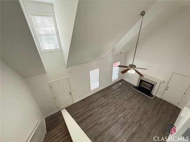 unfurnished living room with ceiling fan, dark hardwood / wood-style flooring, and high vaulted ceiling