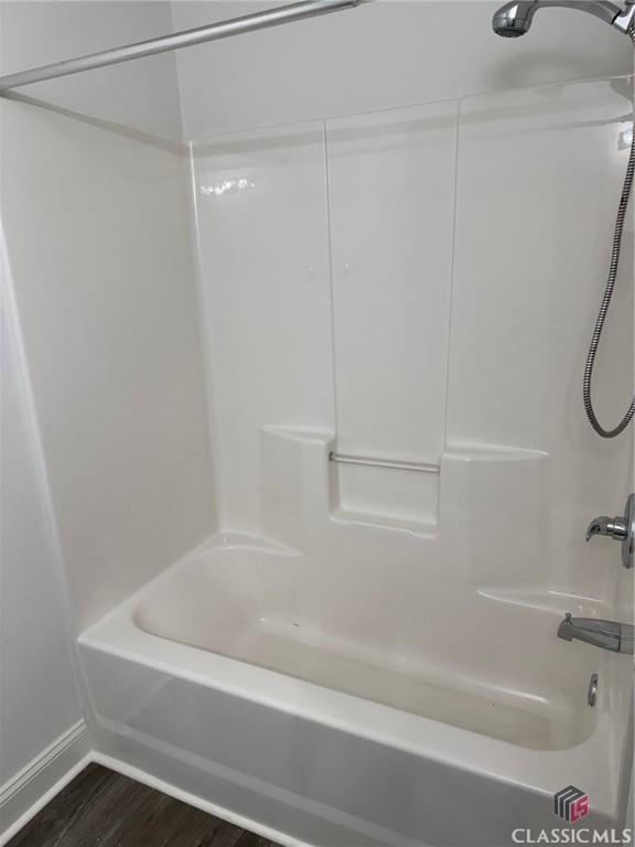 bathroom featuring bathtub / shower combination and hardwood / wood-style flooring