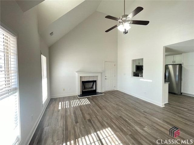 unfurnished living room with ceiling fan, a fireplace, high vaulted ceiling, and dark hardwood / wood-style floors