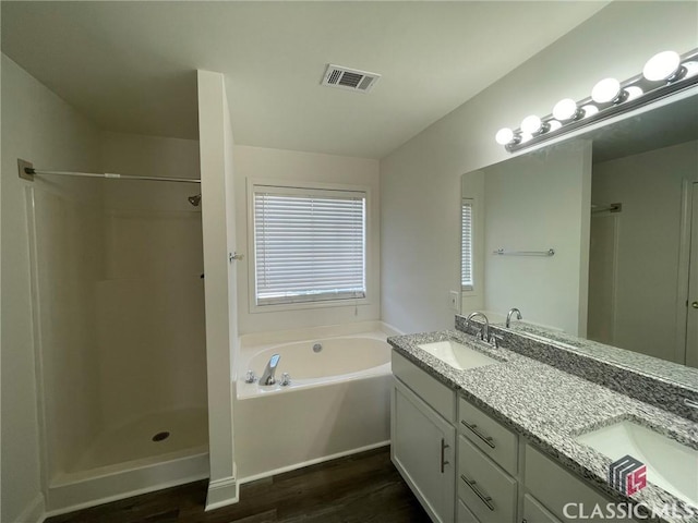 bathroom with hardwood / wood-style floors, vanity, and shower with separate bathtub